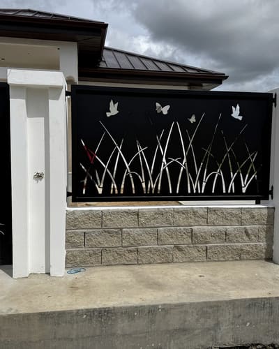 Close view of the boundary fence panels showing grass and butterflies