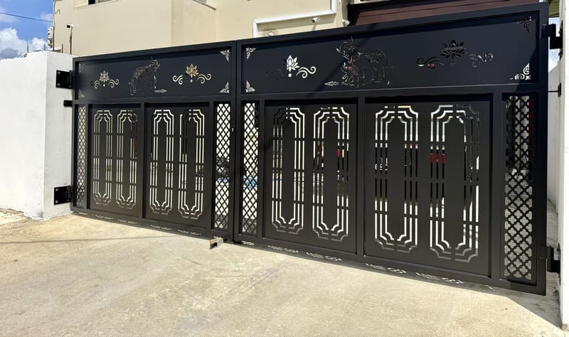 A driveway gate with elephants and lotus flowers cut across the panels