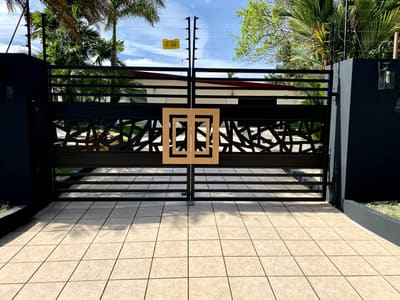 A driveway gate with a fractured geometric pattern cut through the panels